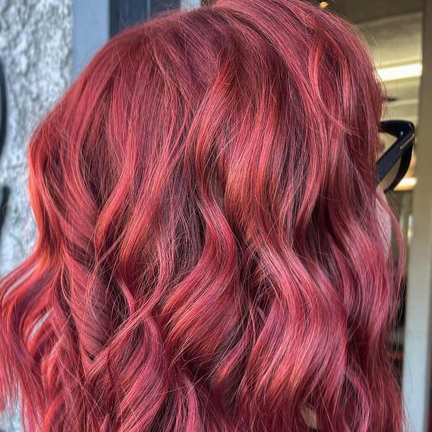 vivid red hair color on a medium short cut styled with loose waves